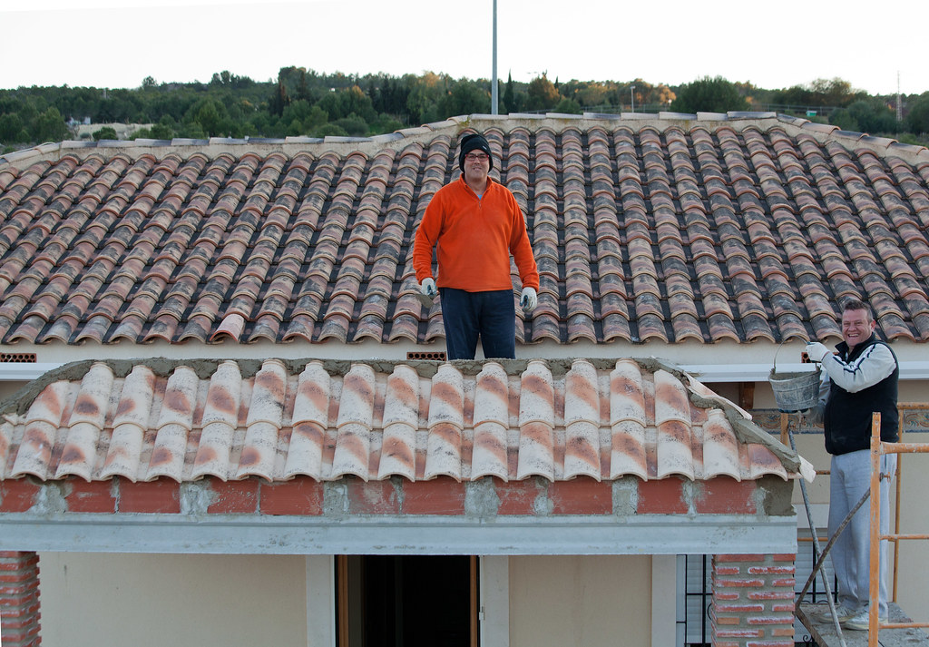 Roofers repairing a tiled roof